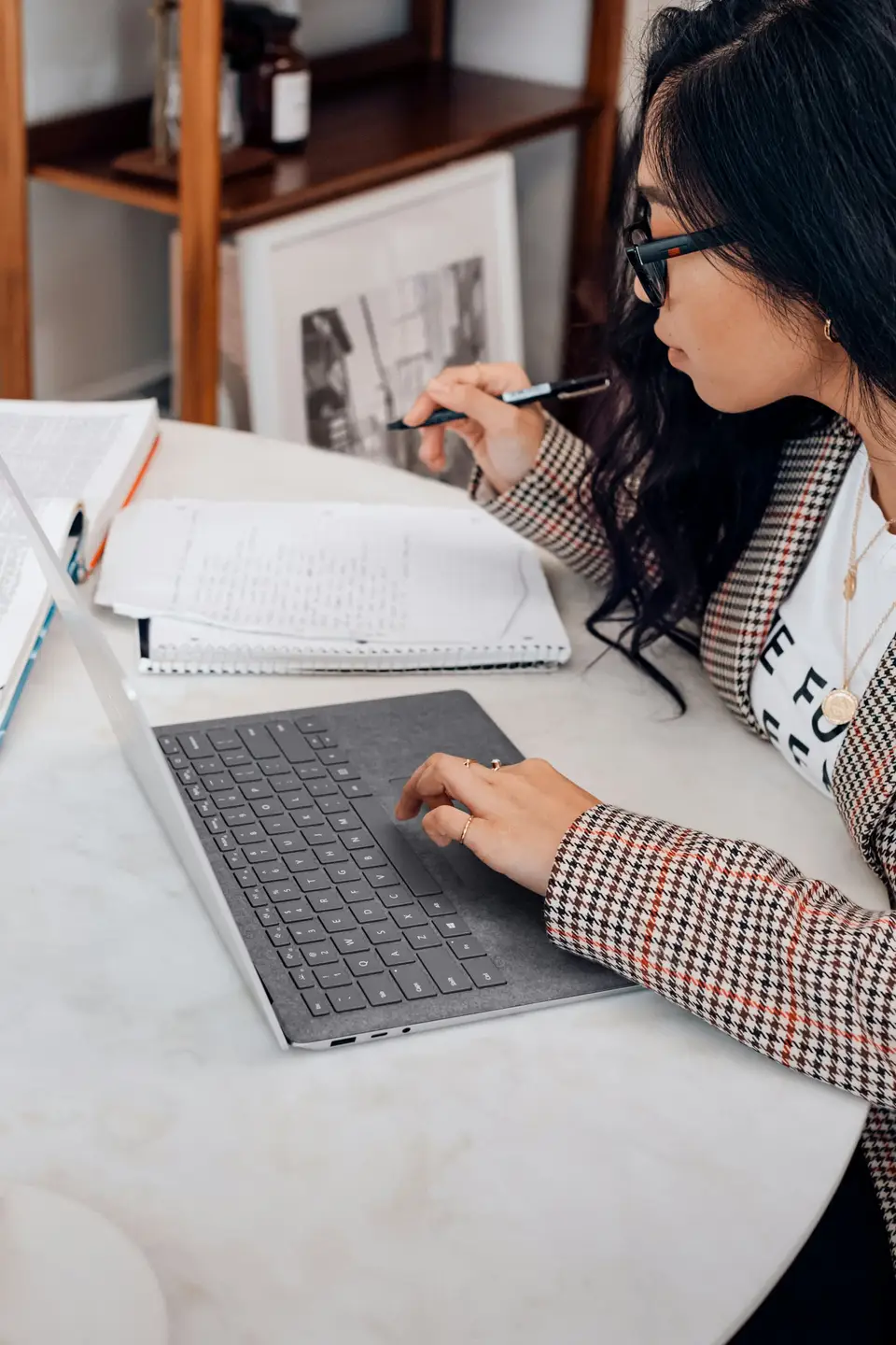An enrolment-team operator working through a lead list on a laptop