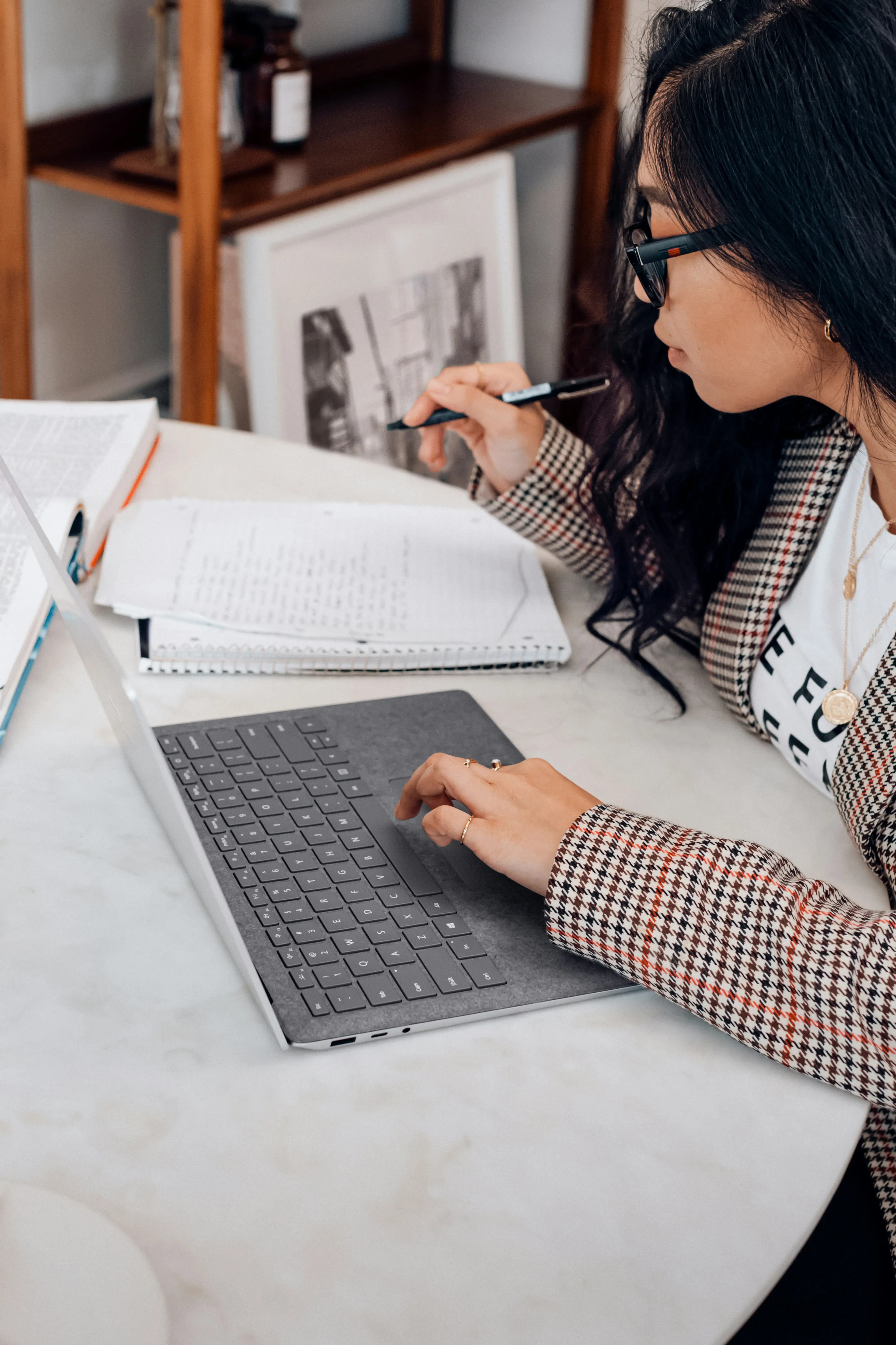 An enrolment-team operator working through a lead list on a laptop
